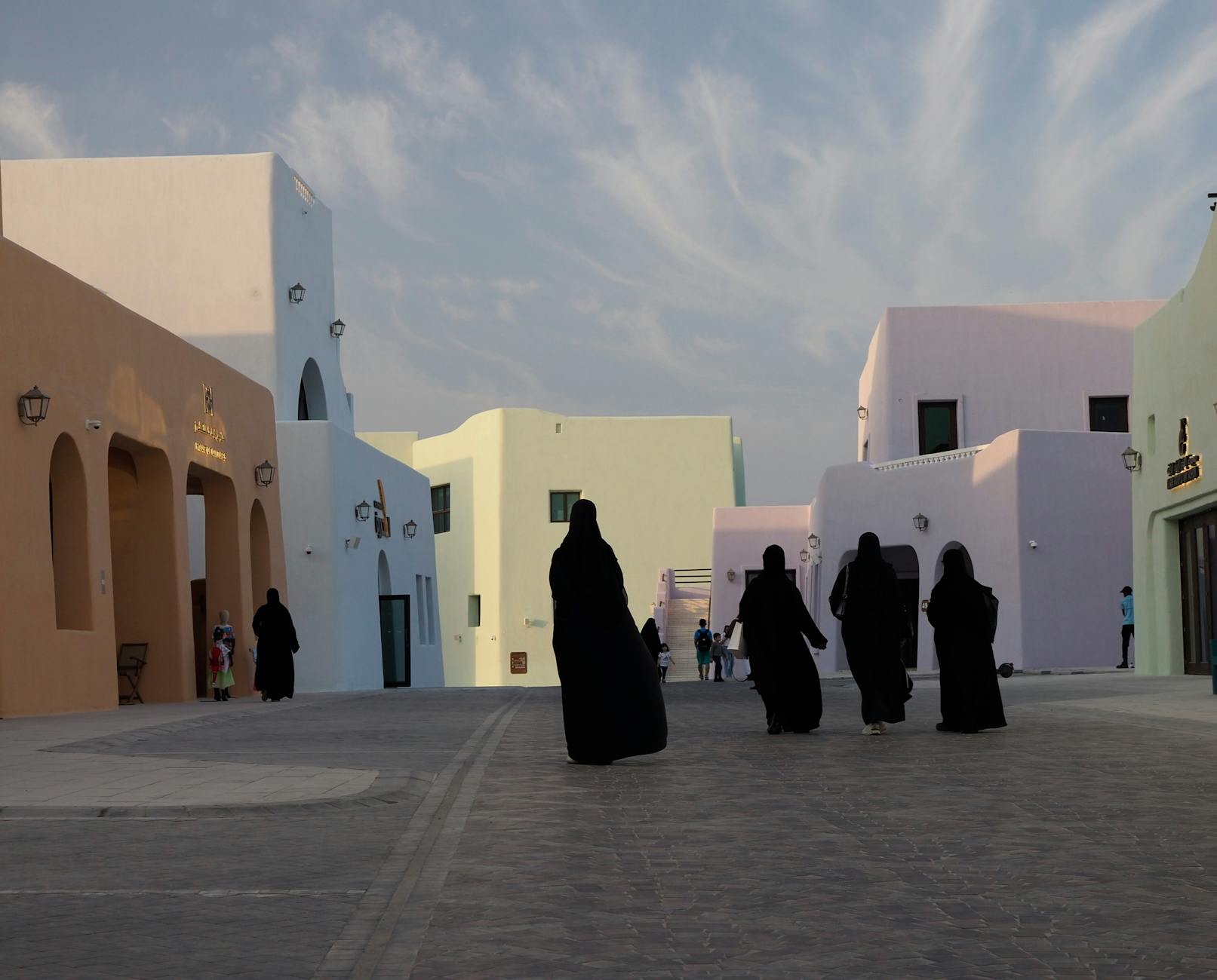 women in abayas walking in town